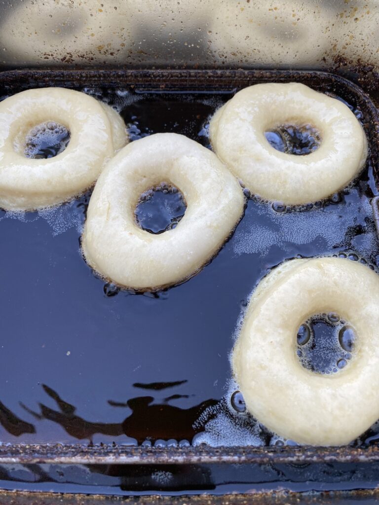 Die Donuts schwimmen im Frittierfett. Dieses Rezept ist für Doughnuts aus Hefeteig. Die Donuts schwimmen im Frittierfett. Dieses Rezept ist für Doughnuts aus Hefeteig.