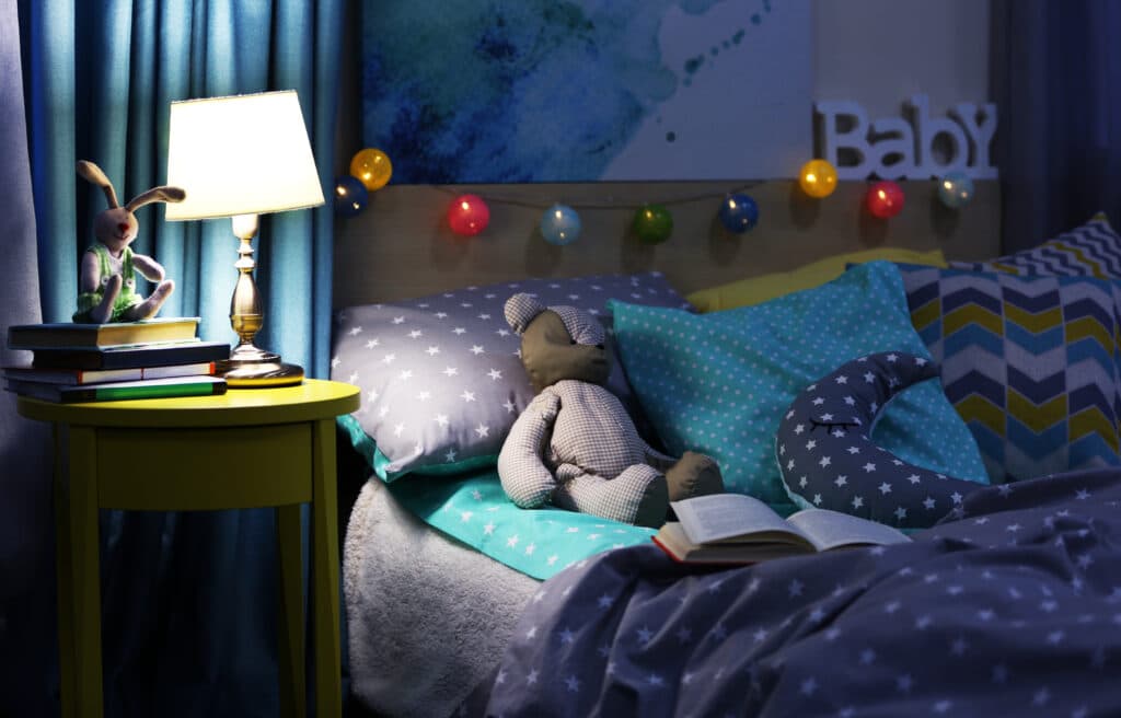 Ein Bär liegt im Bett und wartet darauf, dass eine Gute-Nacht-Geschichte vorgelesen wird.